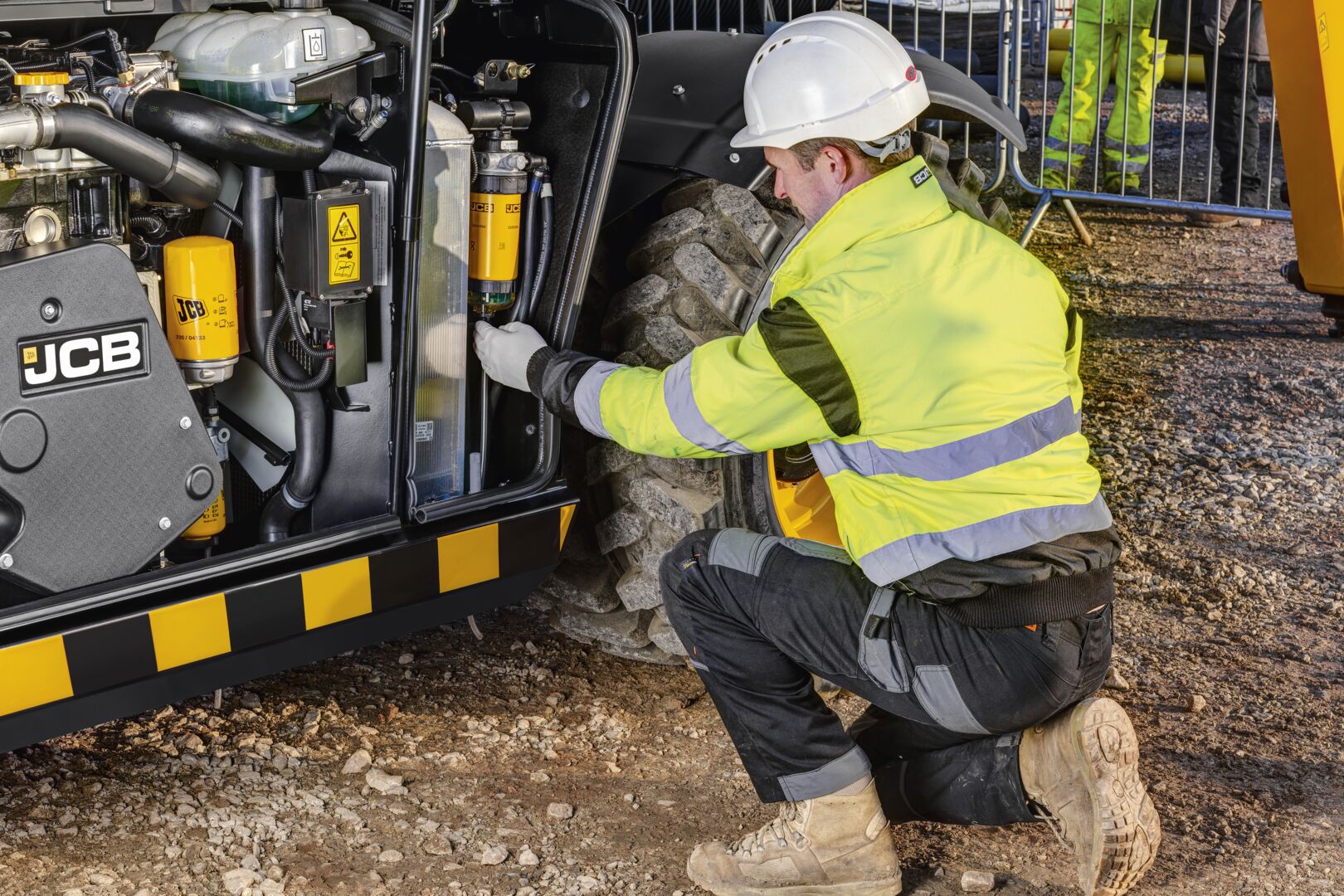 “Technician inspecting engine components on a JCB machine.