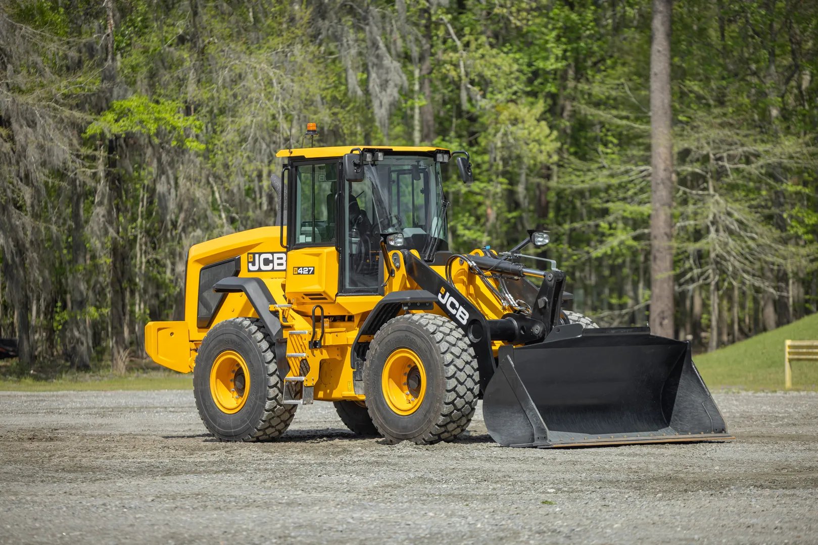 JCB wheel Loader with a JCB bucket on the end and tress in the background